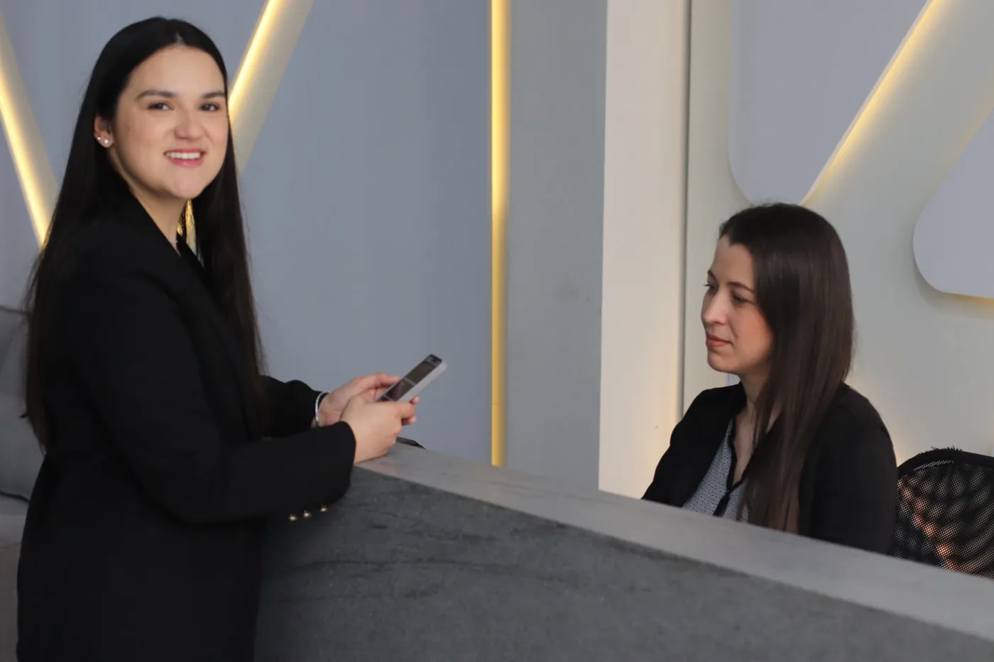 Duas profissionais na recepção de uma empresa