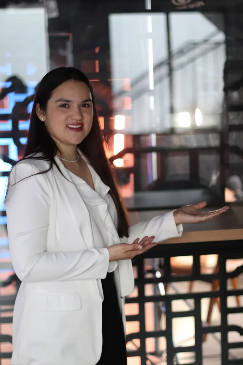 Profissional em blazer branco apresentando em ambiente corporativo